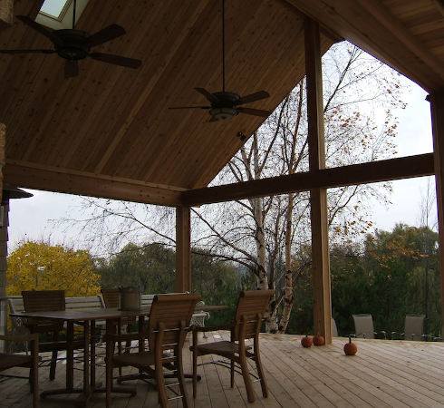 home exterior showing covered wooden deck with table and chairs